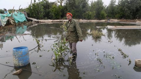 A Palestinian farmer wades through his flooded land after a sewage reservoir in Gaza collapsed last spring. 