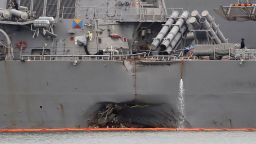 In this Tuesday, Aug. 22, 2017, filephoto, the damaged port aft hull of the USS John S. McCain, is visible while docked at Singapore's Changi naval base in Singapore. The focus of the search for the U.S. sailors missing after a collision between the USS John S. McCain and an oil tanker in Southeast Asian waters shifted Tuesday to the damaged destroyer's flooded compartments. (AP Photo/Wong Maye-E, File)