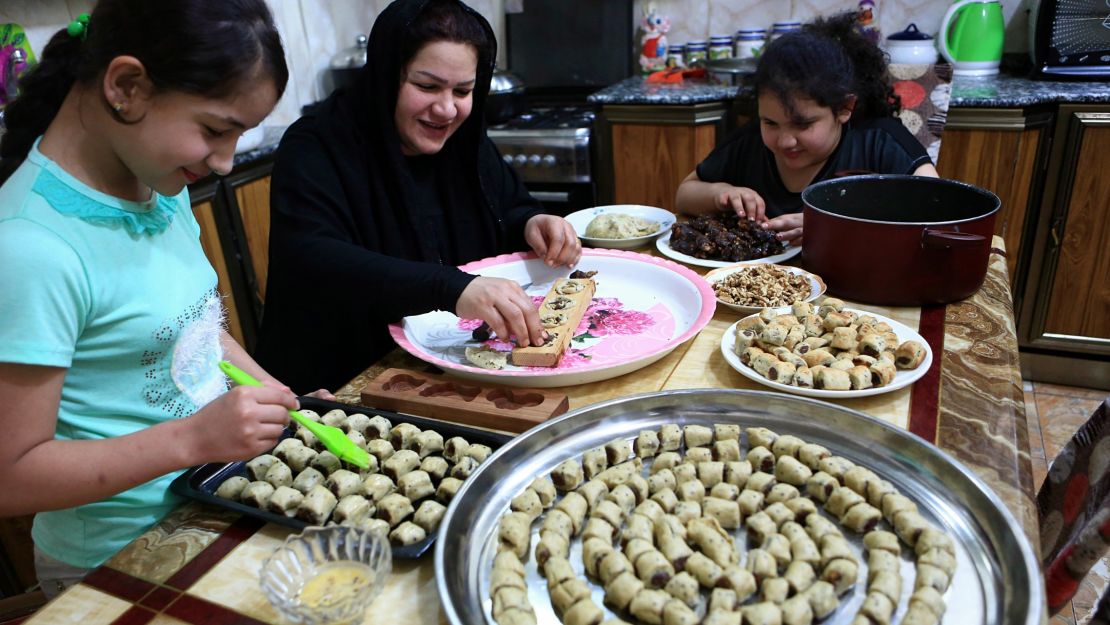 An Iraqi mother and her children prepare cookies for holiday in Basra, Iraq.