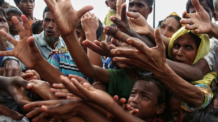 TOPSHOT - This August 30, 2017 photo shows Rohingya refugees reaching for food aid at Kutupalong refugee camp in Ukhiya near the Bangladesh-Myanmar border.
The International Organization for Migration said August 30 that at least 18,500 Rohingya had crossed into Bangladesh since fighting erupted in Myanmar's neighbouring Rakhine state six days earlier.
 / AFP PHOTO / STR        (Photo credit should read STR/AFP/Getty Images)