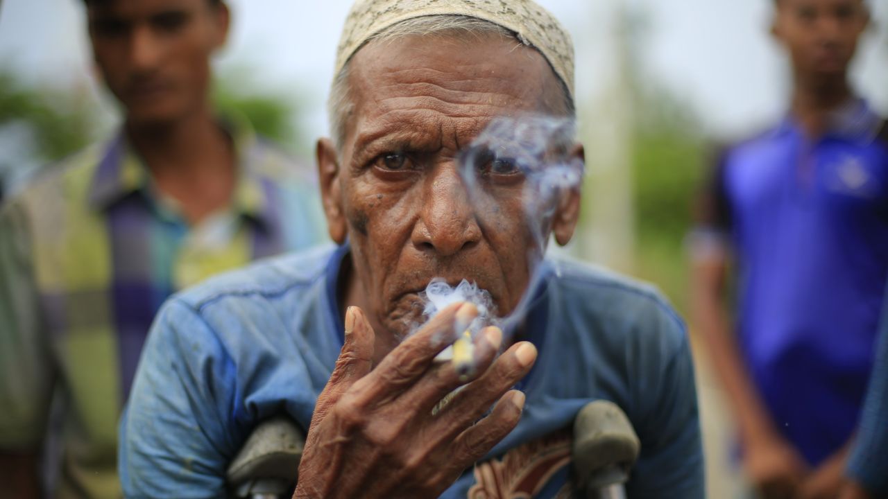 An elderly Rohingya man smokes the last of his Burmese cigar while looking for shelter in Bangladesh with his family near Kutupalang unregistered camp.