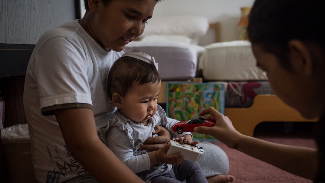 Yalda and Omit play with their 9-month-old sister Elena, the first of the family to be born in Germany.