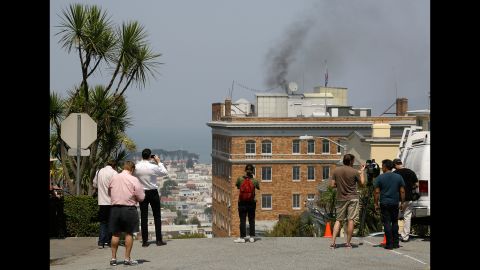 People stop to watch black smoke coming from the Russian Consulate's roof Friday in San Francisco. 