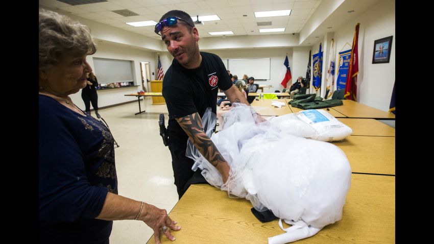 Joyce Brown, left, office manager of the Lumberton Central Fire Station, talks to Firefighter Kyle Parry, who retrieved the wedding dress of his fiancé, Stephanie Hoekstra, not pictured, of Chatham-Kent, Ontario, Canada, from his home, which is flooded as a result of Tropical Storm Harvey on Thursday, August 31, 2017 in Lumberton, Texas. Parry and Hoekstra are supposed to be married on September 10 in Galveston. Parry's home is destroyed, but he was able to retrieve the dress.