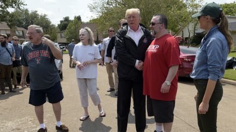 President Donald Trump and first lady Melania Trump talk with people impacted by Hurricane Harvey in a Houston neighborhood on Saturday.
