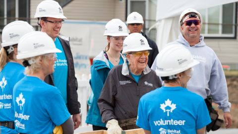 Jimmy Carter (center, in dark jacket) during a Habitat for Humanity project in July.