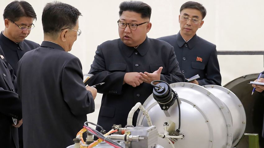 This undated picture released by North Korea's official Korean Central News Agency (KCNA) on September 3, 2017 shows North Korean leader Kim Jong Un, center, looking at a metal casing with two bulges at an undisclosed location. 