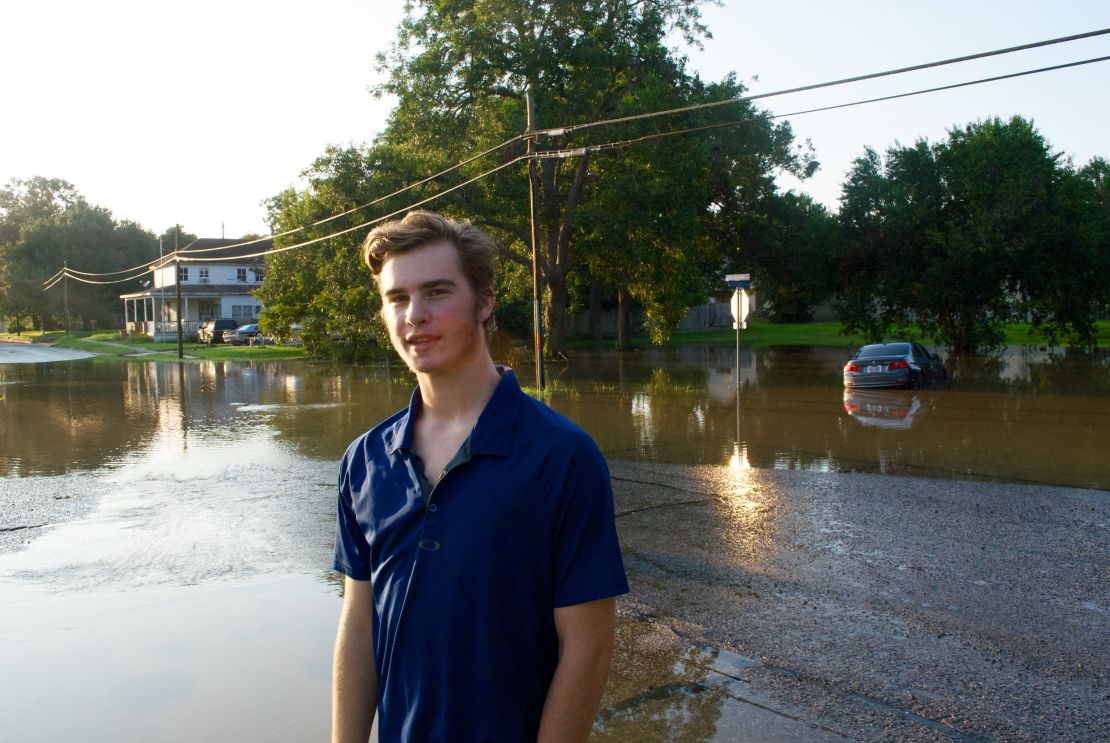 Shane Singleton waded through floodwaters pulling a boat to help neighbors.