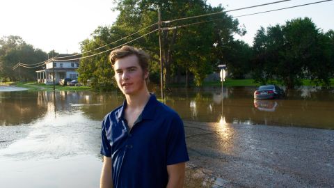 Shane Singleton waded through floodwaters pulling a boat to help neighbors.