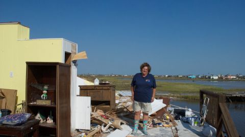 Peggy Bourg stand on the second floor of her ruined home in Holiday Beach.