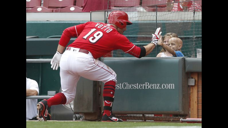 Cincinnati first baseman Joey Votto high-fives Walter Herbert after hitting a home run against the New York Mets on Thursday, August 31. Walter, <a href="index.php?page=&url=https%3A%2F%2Fwww.usatoday.com%2Fstory%2Fsports%2Fmlb%2F2017%2F08%2F31%2Freds-joey-votto-superbubz-walter-herbert-home-run%2F621821001%2F" target="_blank" target="_blank">a 6-year-old battling cancer,</a> also received a bat and a jersey from Votto after the home run.