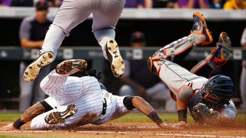 Colorado's Ian Desmond, bottom left, is tagged out by Detroit catcher James McCann during a play at the plate on Tuesday, August 29.