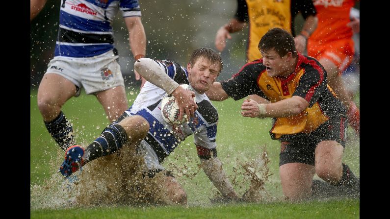 Wanganui rugby player Simon Dibben slides into the mud as Travis Scott tackles him in Paeroa, New Zealand, on Saturday, September 2.