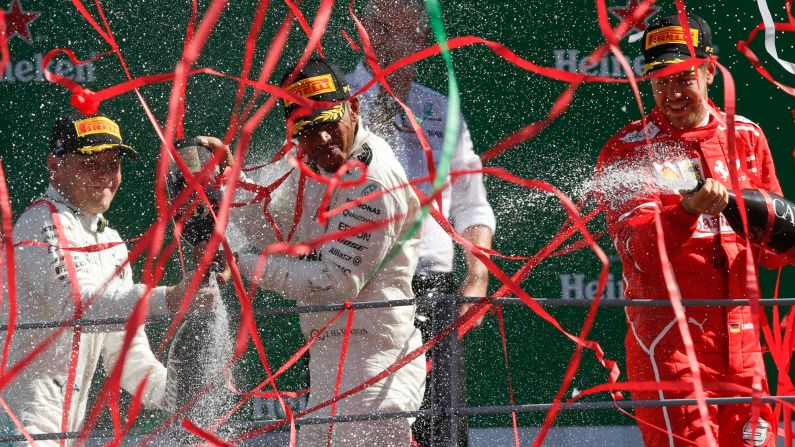 Formula One driver Lewis Hamilton, center, celebrates <a href="index.php?page=&url=http%3A%2F%2Fwww.cnn.com%2F2017%2F09%2F03%2Fmotorsport%2Flewis-hamilton-wins-monza-formula-one-sebastian-vettel-ferrari%2Findex.html" target="_blank">his win in the Italian Grand Prix</a> on Sunday, September 3. Joining him on the podium were second-placed Valtteri Bottas, left, and third-placed Sebastian Vettel.