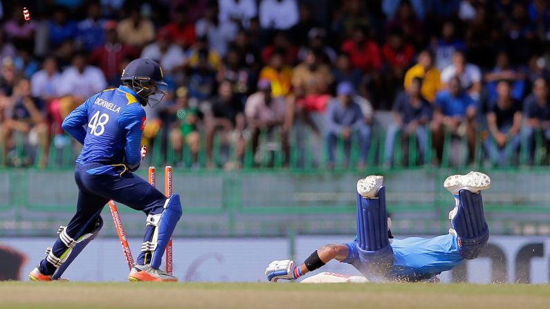 Sri Lankan wicketkeeper Niroshan Dickwella dislodges the stumps as Indian captain Virat Kohli successfully dives into the crease during a cricket match in Colombo, Sri Lanka, on Thursday, August 31. India swept Sri Lanka in five one-day internationals.