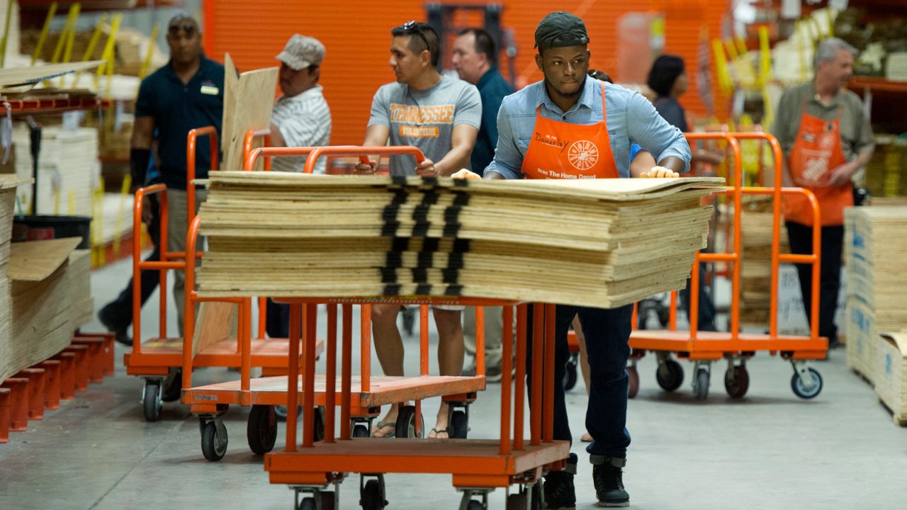 An employee pushes plywood to the checkout line at a Home Depot in West Palm Beach on Monday.
