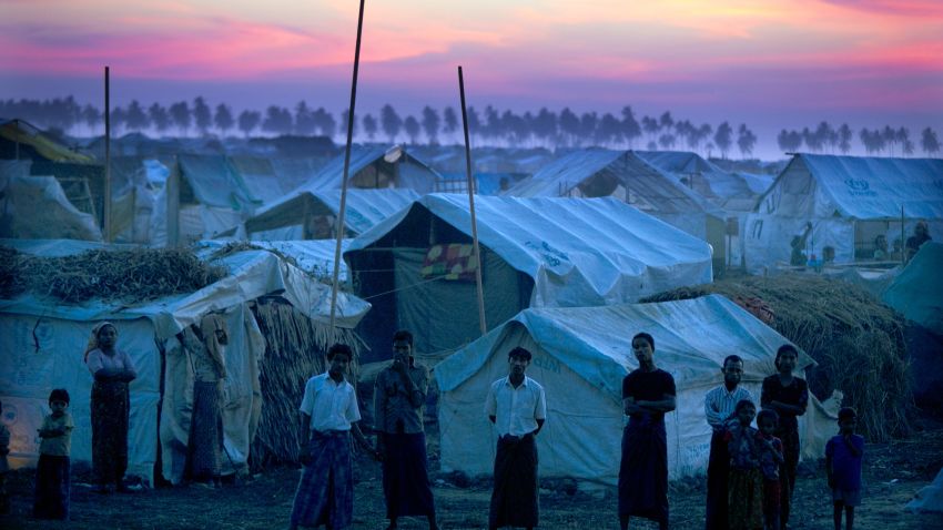 SITTWE, MYANMAR - NOVEMBER 24: Rohingya refugees stand at a crowded internally displaced persons (IDP) camp after sunset November 24, 2012 on the outskirts of Sittwe, Myanmar. An estimated 111,000 people were displaced by sectarian violence in June and October, effecting mostly the ethnic Rohingya people, who are now living in crowded IDP camps racially segregated from the Rakhine Buddhists in order to maintain stability. Around 89 lives were lost during a week of violence in October, the worst in decades. As of 2012, 800,000 Rohingya live in Myanmar. According to the UN, they are one of the most persecuted minorities in the world. (Photo by Paula Bronstein/Getty Images)