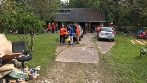 Volunteers gather outside Frances French's flood-damaged home.