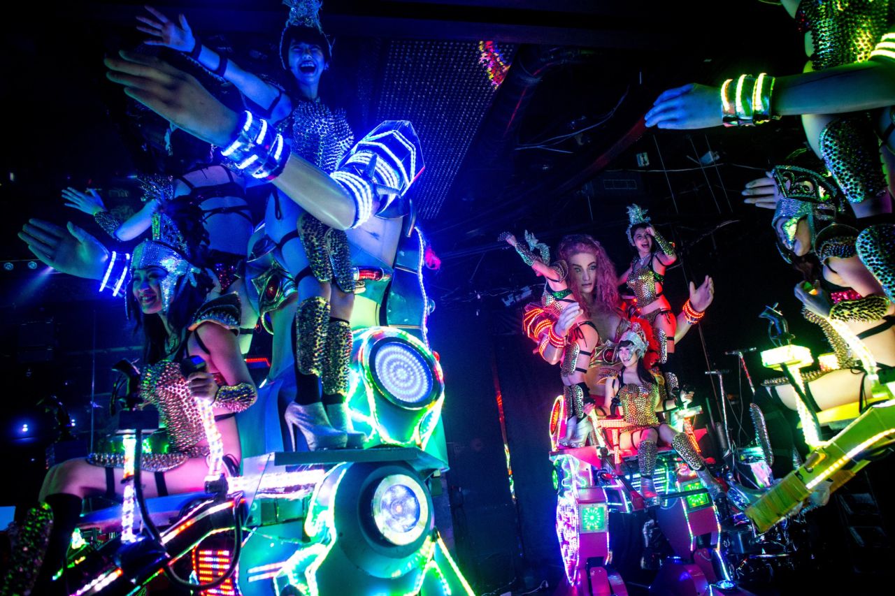 Dancers perform on large scale "female" robots.