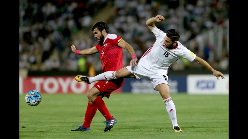Tamer Haj Mohamad tries to shield the ball from Alireza Jahanbakhsh.