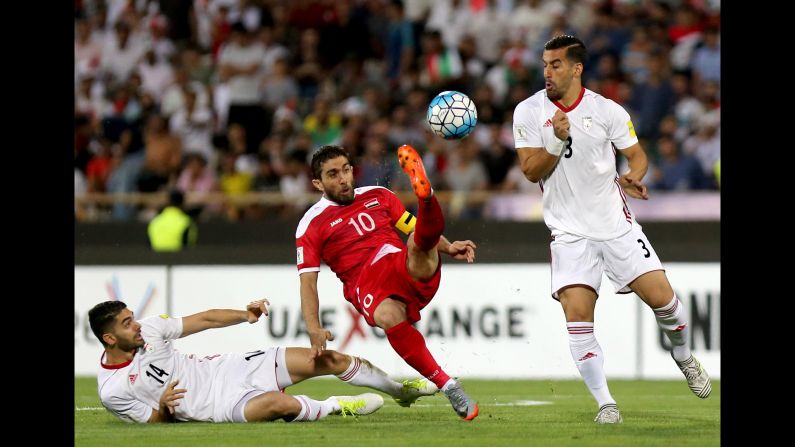 Firas Mohamad Al-Khatib competes with Iranian players Ali Karimi, left, and Ehsan Hajsafi. Iran has already clinched a spot in the World Cup.