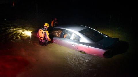 First responders check an empty car caught in floodwaters Wednesday in Fajardo, Puerto Rico. 