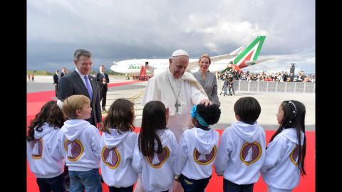 Francis, here with Colombian President Juan Manuel Santos and first lady Maria Clemencia Rodriguez, greets children during a welcoming ceremony September 6 at El Dorado International Airport in Bogota.