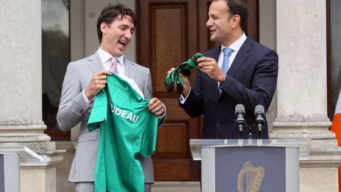 Canada's Prime Minister Justin Trudeau (L) is presented with an Ireland rugby union shirt and a pair of socks, by Ireland's Prime Minister Leo Varadkar (R) at Farmleigh House in Dublin on July 4, 2017.