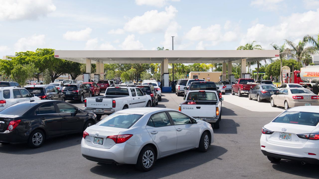 People wait in line at a Costco Gas Station in Miami on Thursday.
