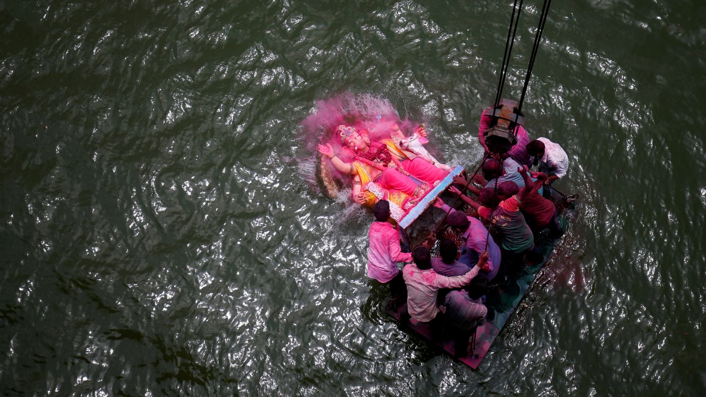 People immerse an idol of the Hindu god Ganesh into the Sabarmati River during a festival in Ahmedabad, India, on Tuesday, September 5.