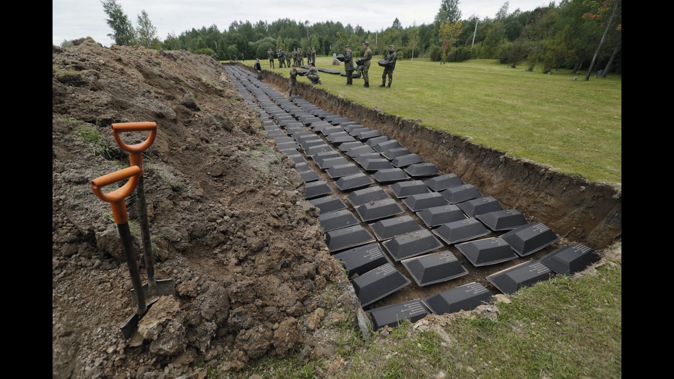 German and Russian soldiers take part in a reburial ceremony Wednesday, September 6, for hundreds of German soldiers who were killed during World War II. The remains were found in Russia's Leningrad region and reburied at a cemetery in Sologubovka, Russia.