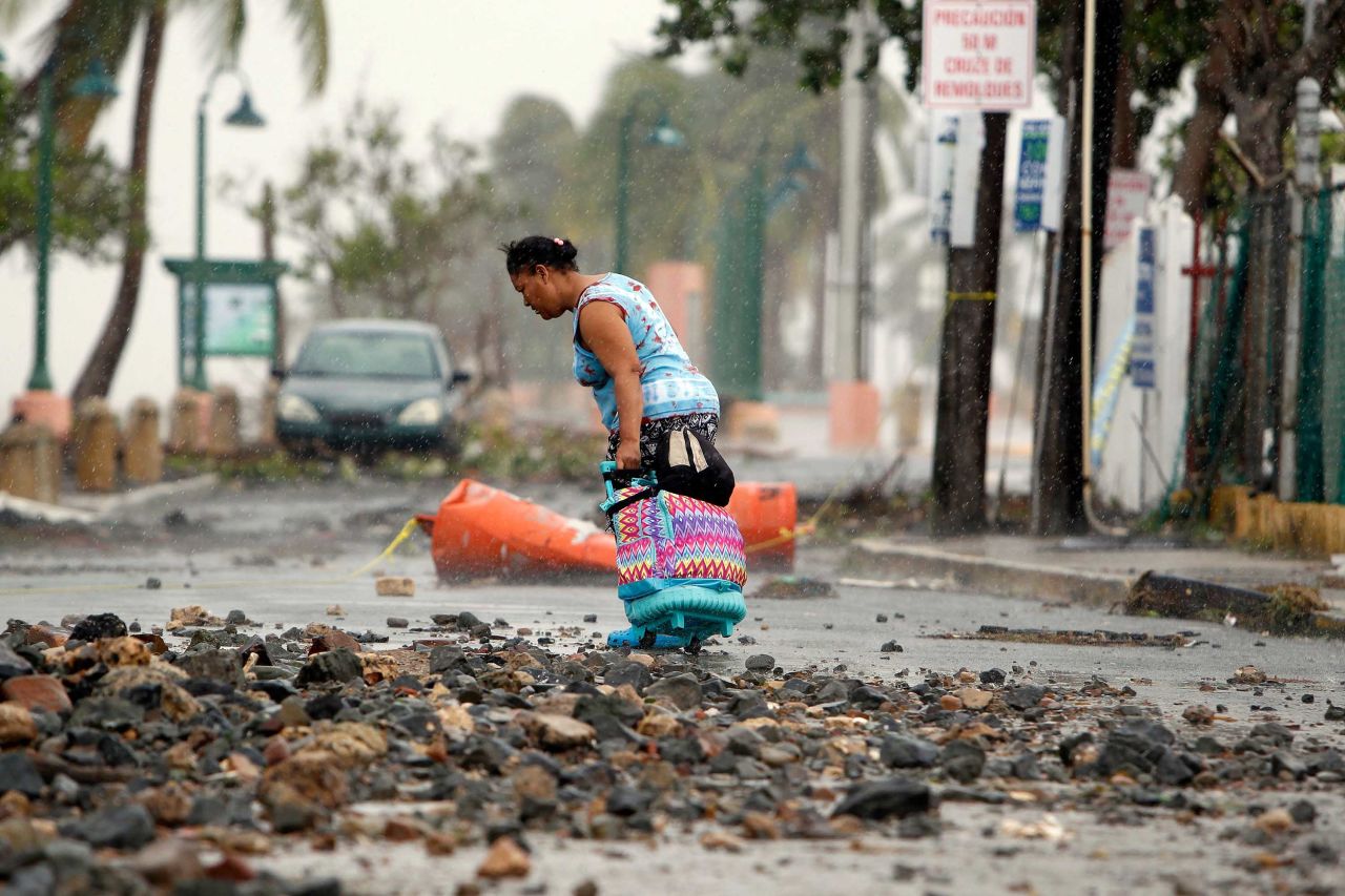 A woman makes her way through debris in Fajardo, Puerto Rico, on September 7.