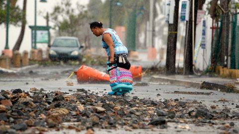 A woman pulls a suitcase through debris in Fajardo, Puerto Rico, on September 7.