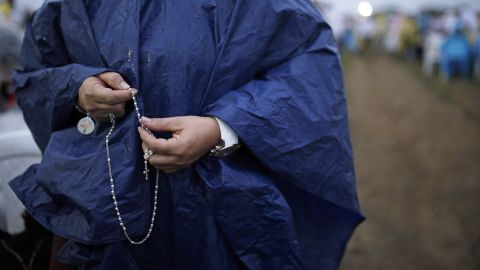 A woman holding a rosary awaits the start of a Mass in Villavicencio on September 8.