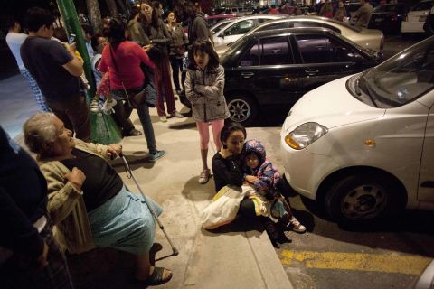People sit on a sidewalk in Mexico City after the quake.