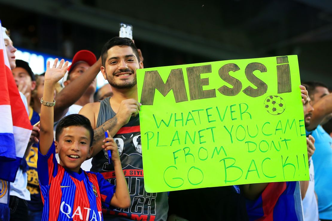 Barcelona fans pose with a sign for Lionel Messi in Miami. The Argentine could be returning sooner than they think.