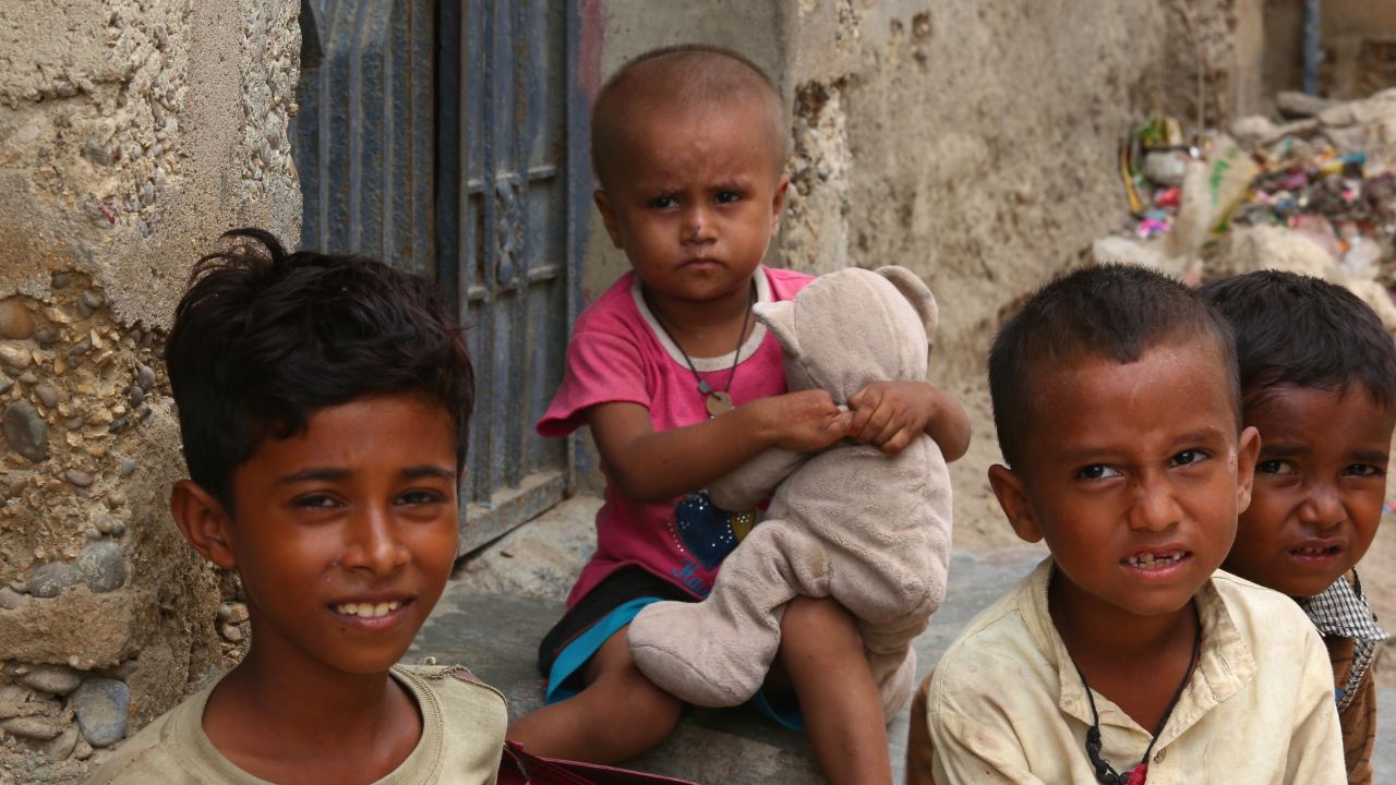 A Rohingya child clutches a battered teddy bear.