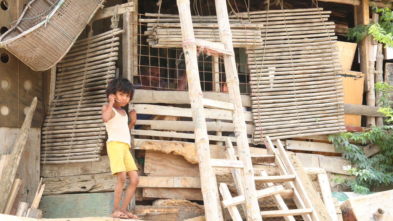 A young Rohingya child stands by a dwelling in the Arakanabad slum.