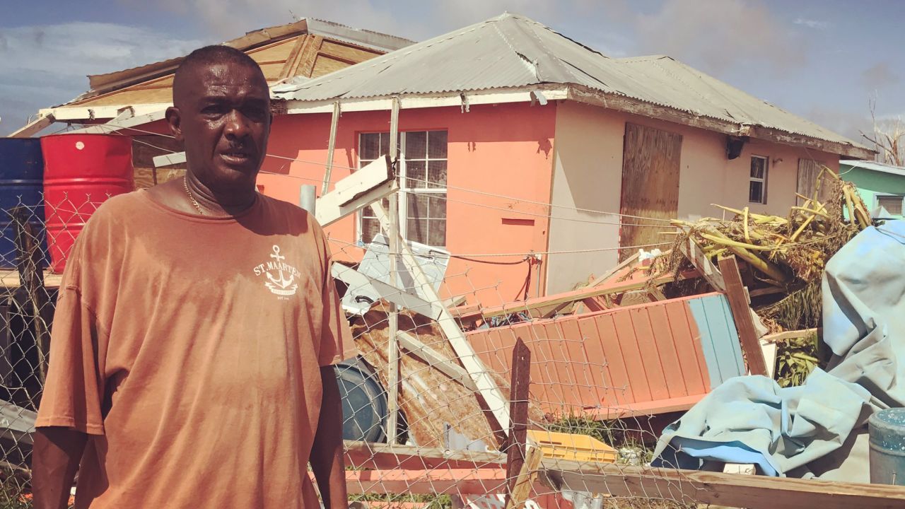 Elvis Burton stands outside his boarded-up home in Barbuda.