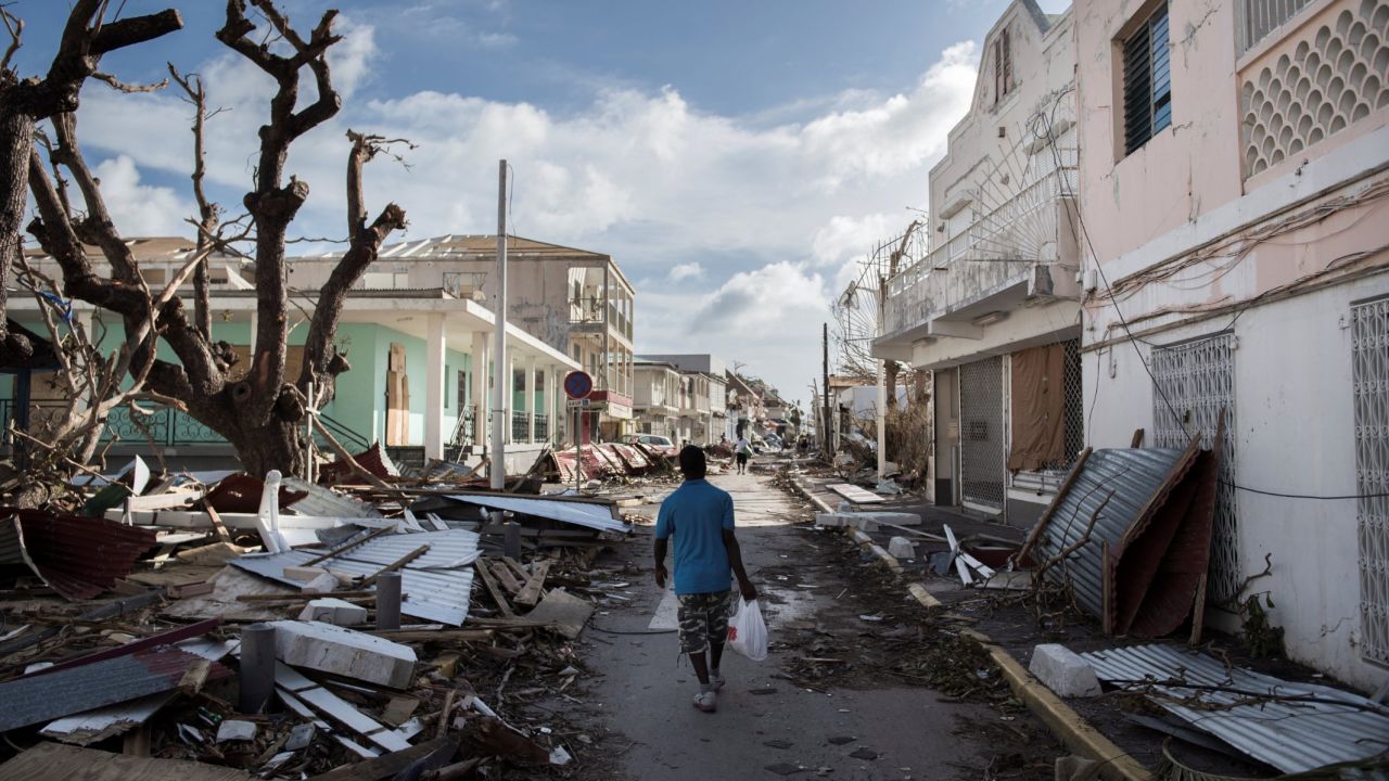 A man walks on a St. Martin street covered in debris on September 8.