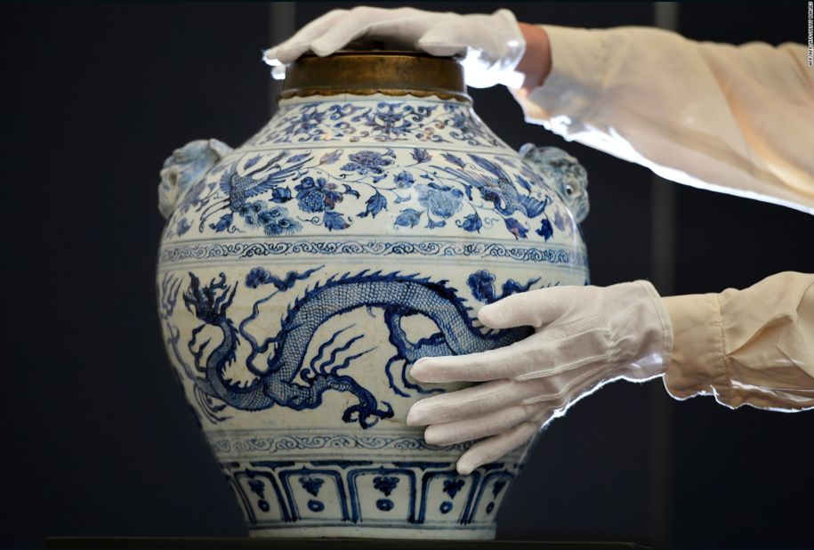 An employee poses with a Yuan dynasty blue and white "Dragon and Phoenix" jar expected to realize 400,000-600,000 GBP ($637,600-$956,400USD) at auction as part of the forthcoming Sotheby's Fine Chinese Ceramics and Works of Art auction in London on November 2, 2012. 