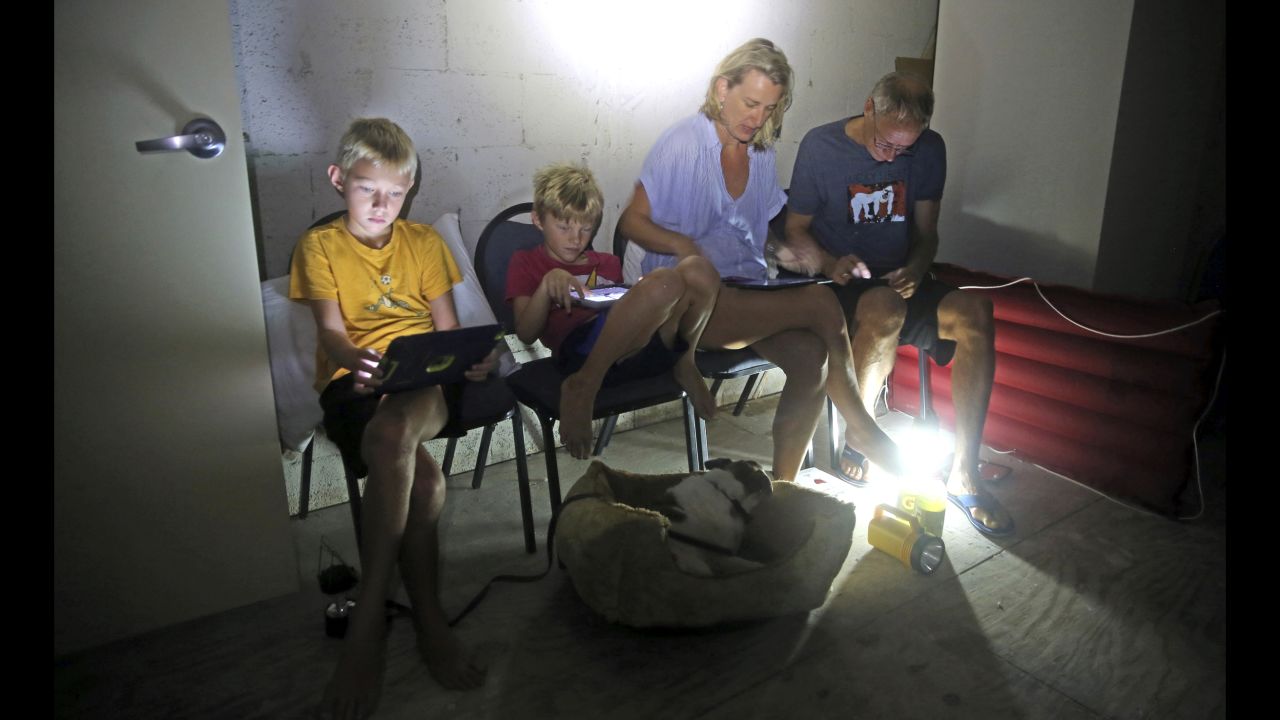 Members of the Blinckman family use their personal devices in a stairwell utility closet as Hurricane Irma went over Key West, Florida, on September 10.
