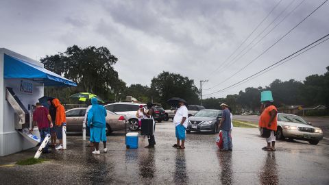 A local volunteer from Crossing Jordan Church helps other residents get ice from a vending machine on September 10 in Tampa.