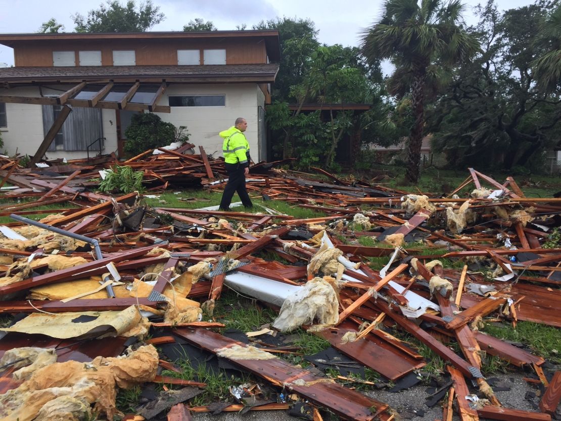 Palm Bay police officer Dustin Terkoski walks over debris from a two-story home at Palm Point subdivision in Brevard County, Florida, after a tornado touched down on Sunday.