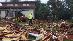 Palm Bay officer Dustin Terkoski walks over debris from a two-story home at Palm Point Subdivision in Brevard County, Fla., after a tornado touched down on Sunday, Sept. 10, 2017. (Red Huber/Orlando Sentinel via AP)