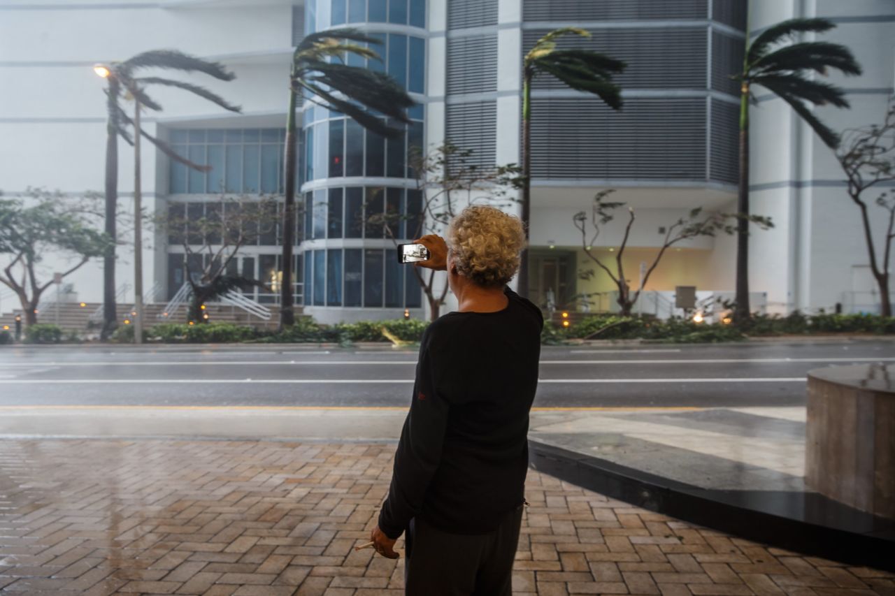A man records the gusty winds going through downtown Miami on September 10.