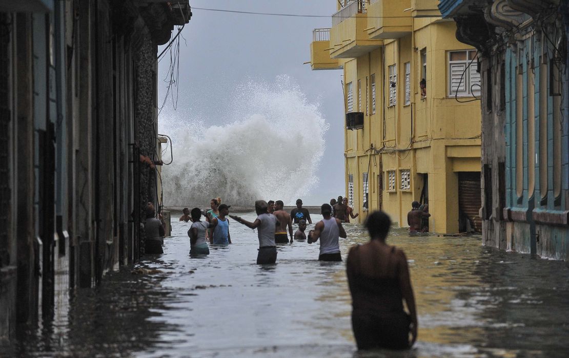 Cubans wade through a flooded street in Havana in the wake of hurricane Irma.