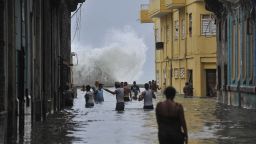 TOPSHOT - Cubans wade through a flooded street in Havana, on September 10, 2017.Deadly Hurricane Irma battered central Cuba on Saturday, knocking down power lines, uprooting trees and ripping the roofs off homes as it headed towards Florida. Authorities said they had evacuated more than a million people as a precaution, including about 4,000 in the capital. / AFP PHOTO / YAMIL LAGE        (Photo credit should read YAMIL LAGE/AFP/Getty Images)