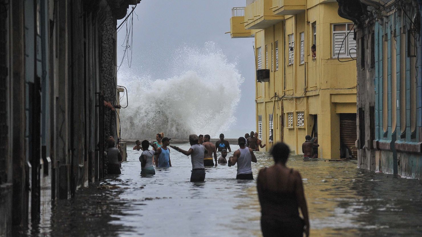  Cubans wade through a flooded street in Havana on Sunday.