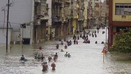 People move through flooded streets in Havana after the passage of Hurricane Irma, in Cuba, Sunday, Sept. 10, 2017. The powerful storm ripped roofs off houses, collapsed buildings and flooded hundreds of miles of coastline after cutting a trail of destruction across the Caribbean. Cuban officials warned residents to watch for even more flooding over the next few days. (AP Photo/Ramon Espinosa)